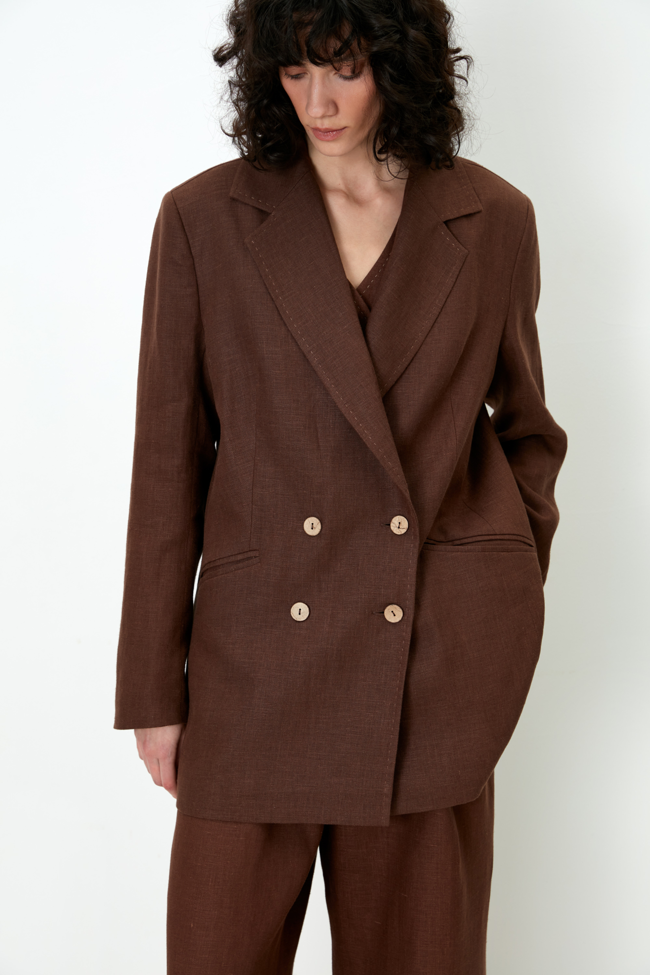 Классический двубортный жакет из 100% льна. Модель прямого кроя с английским воротником и прорезными карманами с клапанами. Изделие декорировано отстрочкой контрастного цвета. На подкладке.