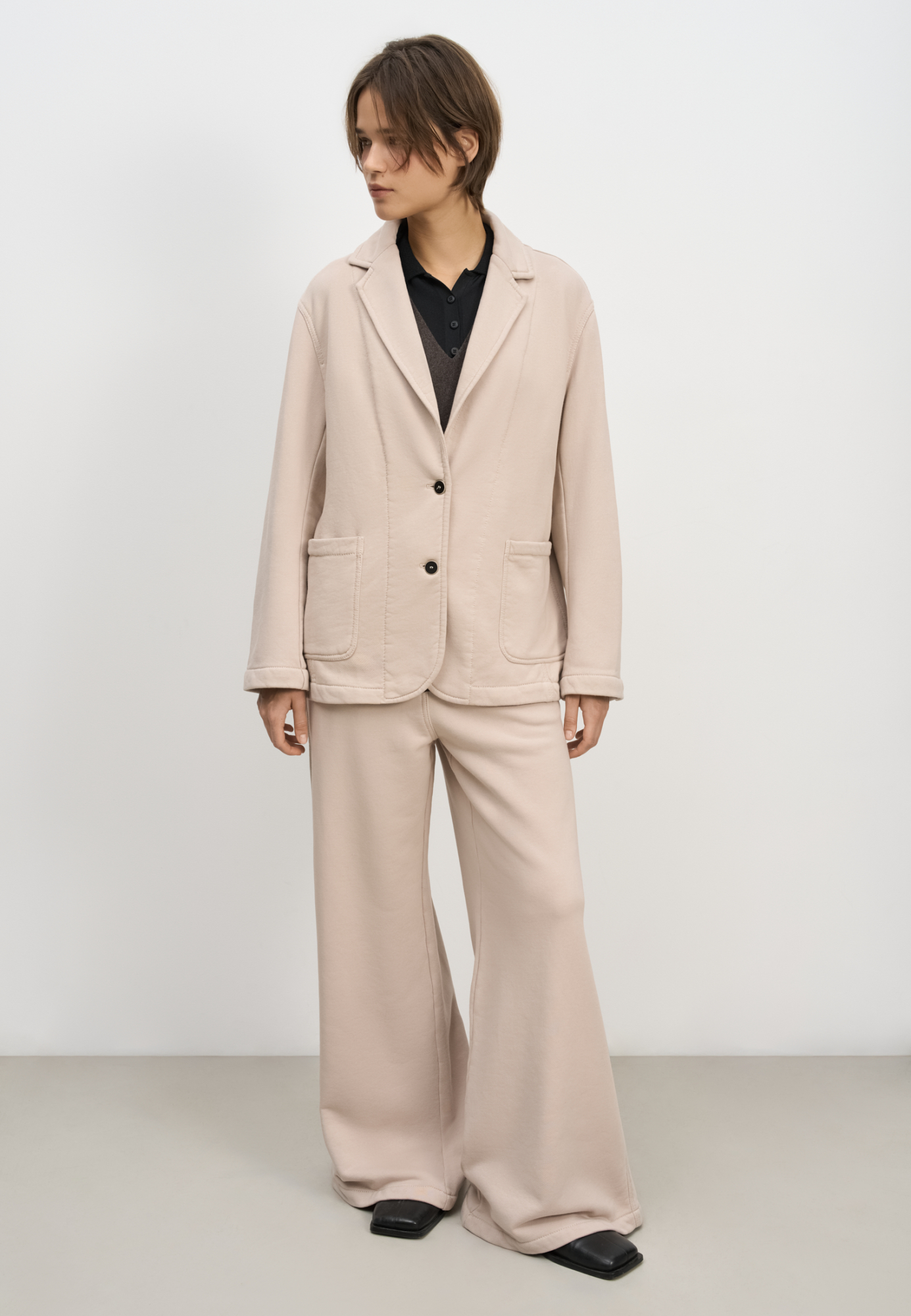 Однобортный жакет свободного силуэта. Модель с накладными карманами, спущенной линией плеча и контрастной отстрочкой. Дополнить образ можно брюками в таком же стиле.