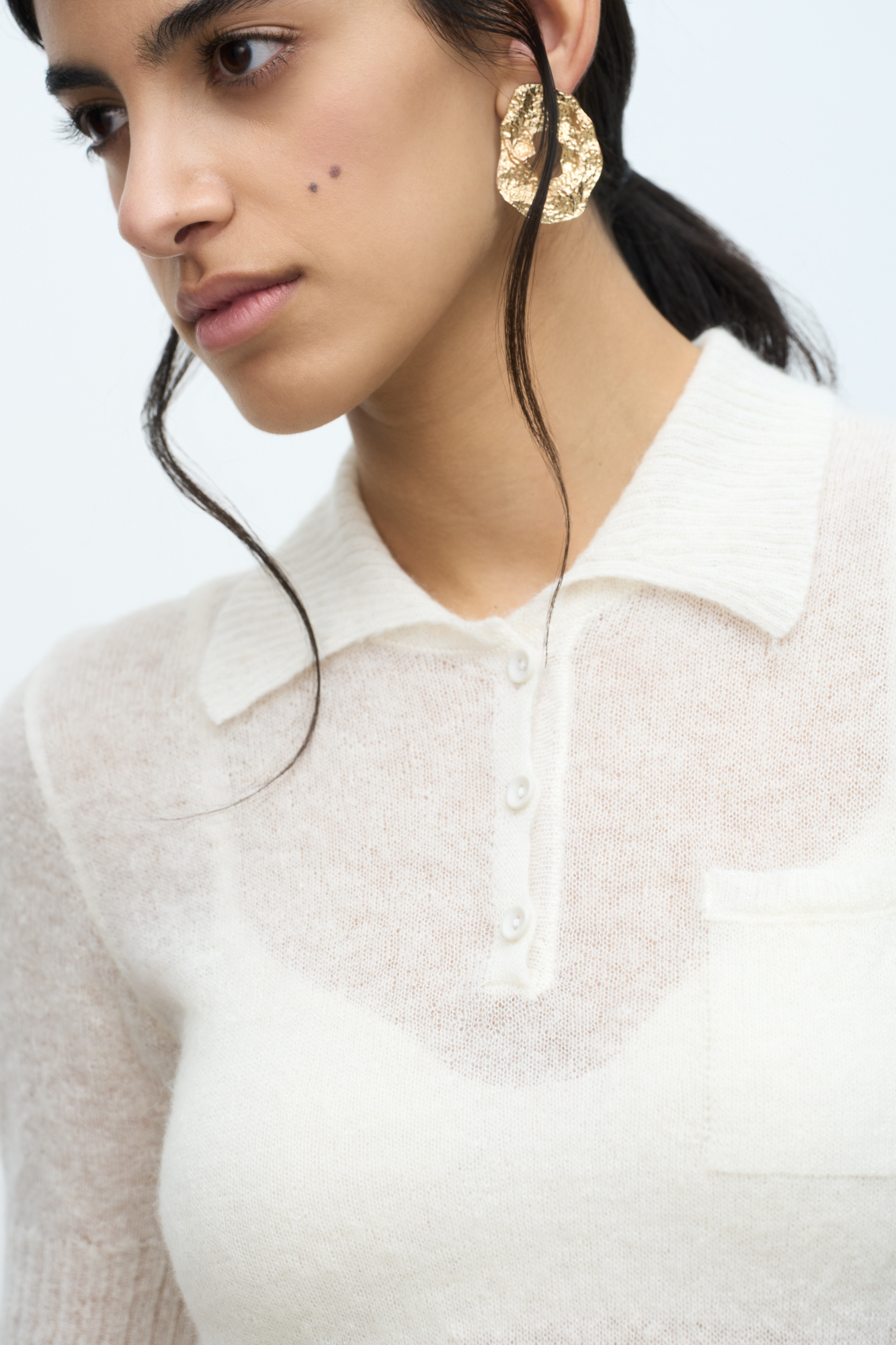 Трикотажная футболка из шерсти мериноса и альпака. Модель прямого силуэта с воротником-поло на пуговицах. Края изделия выполнены в рубчик. 