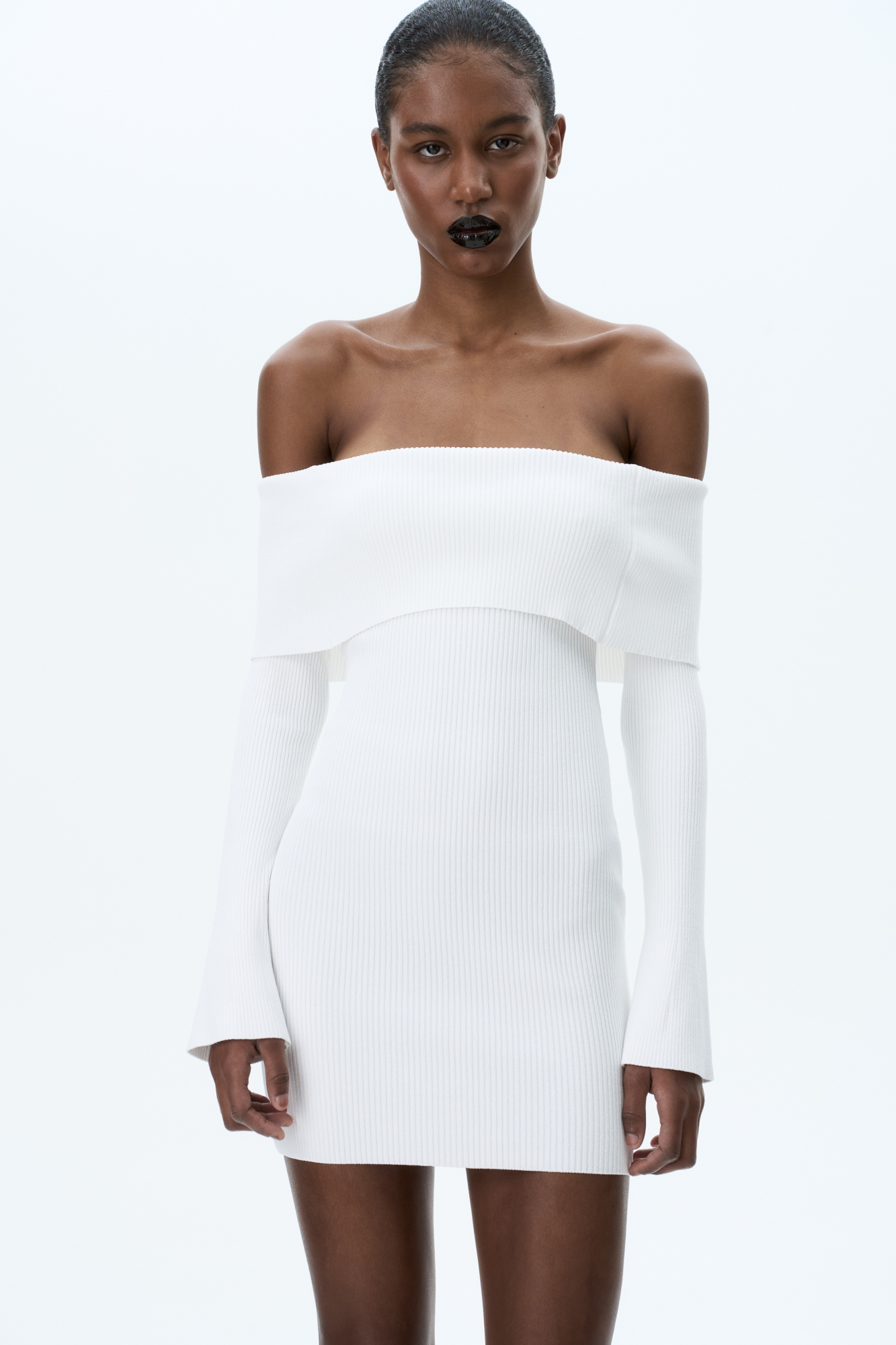 Трикотажное платье длины мини из вискозы в рубчик. Модель приталенного силуэта, с длинными рукавами и открытой линией плеч.