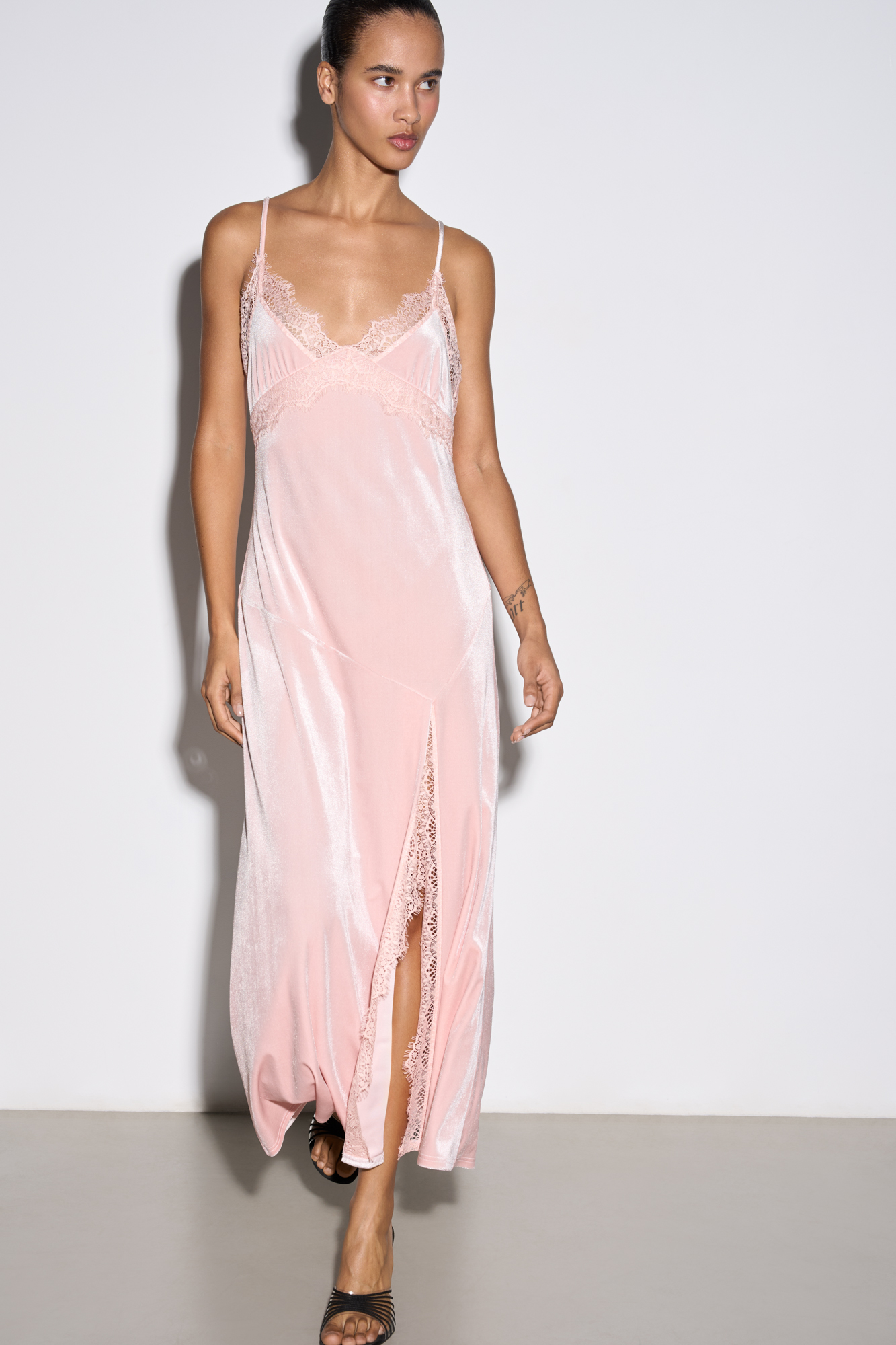 Платье-комбинация длины макси из бархатной вискозы. Модель приталенного силуэта на тонких бретельках и высоким разрезом сбоку. Изделие декорирорвано кружевом.