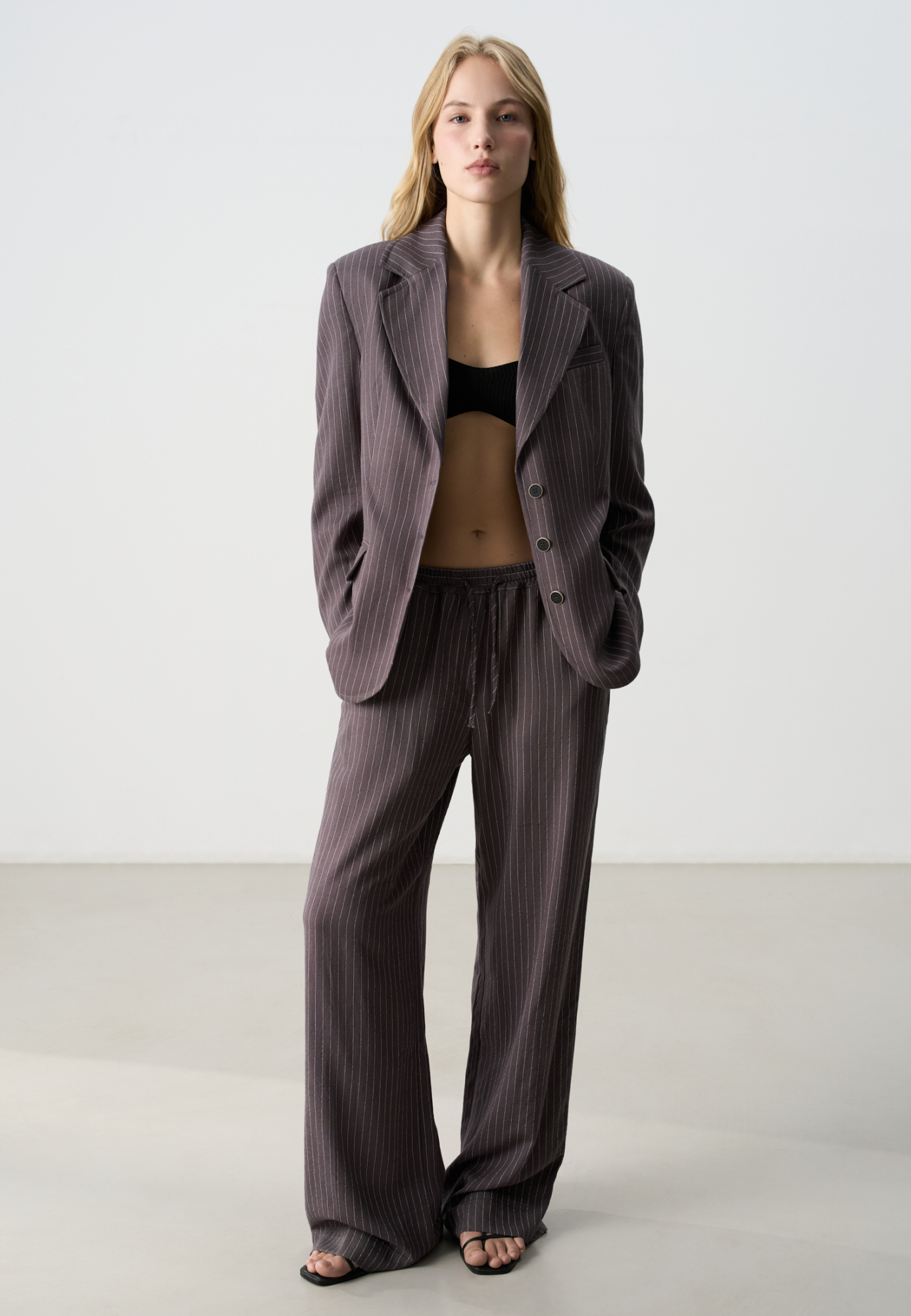 Брюки в полоску изо льна с добавлением вискозы. Модель прямого кроя, с эластичным поясом на кулиске. Дополнить образ можно жакетом. 