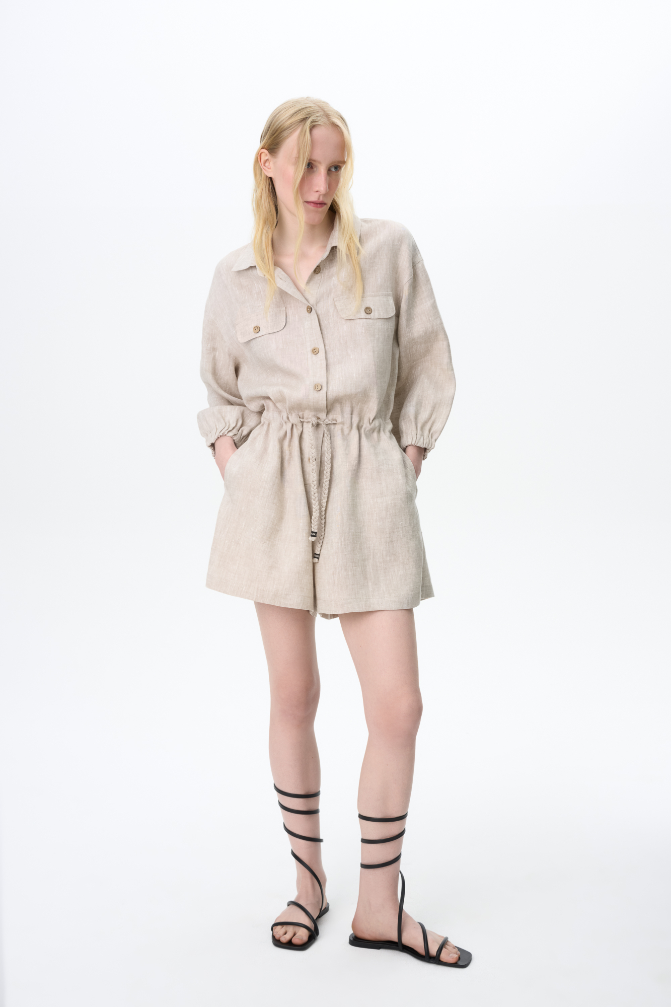 Комбинезон из 100% льна. Модель с рубашечным верхом, отложным воротником, накладными карманами на груди, длинными рукавами и застежкой на пуговицы. Регулируемая кулиска на поясе. 