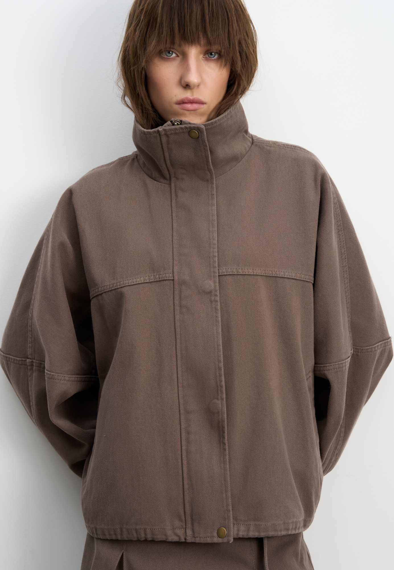 Джинсовая куртка из 100% хлопка. Модель прямого кроя с объемными рукавами и высоким воротником-стойкой. Застежка на скрытую молнию под широкой планкой с кнопками. Манжеты рукавов выполнены на резинке. 