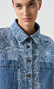 Принтованная джинсовая рубашка из 100% хлопка. Модель укороченного силуэта, с длинными рукавами с манжетами, классическим отложным оротником и двумя нагрудными карманами. Застежка на пуговицы. 