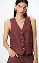 Жилет изо льна. Модель прямого кроя с V-образным вырезом и имитацией карманов. Застежка на пуговицы. Дополнить образ можно джинсами в таком же стиле.