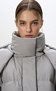 Пуховик с двумя накладными карманами, воротником-стойкой и капюшоном. Застежка на молнию под планкой. Низ изделия выполнен на регулируемой кулиске. На подкладке.