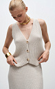 Трикотажный жилет из шерсти. Модель прямого кроя с V-образным вырезом и застежкой на пуговицы. Дополнить образ можно юбкой в таком же стиле.