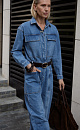 Джинсовый комбинезон из 100% хлопка. Модель с рубашечным верхом с длинными рукавами, отложным воротником и большими нагрудными карманами.<br />
Брюки изделия широкие, прямые, полной длины, с большими накладными карманами и шлевками на поясе для ремня.