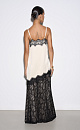 Юбка длины миди, выполненная из кружева на подкладке контрастного цвета. Модель прямого силуэта, с разрезом сзади и застежкой на молнию.