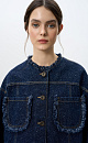 Джинсовый жакет из 100% хлопка. Модель свободного силуэта со спущенной линией плеча и накладными карманами. Застежка на металлические пуговицы. Изделие декорировано бахромой на карманах, манжетах рукавов и воротнике. Дополнить образ можно юбкой в таком же стиле.