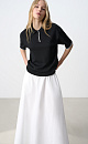 Трикотажная футболка поло из вискозы. Модель прямого силуэта, со спущенной линией плеч, короткими рукавами, отложным воротником-поло и планкой с тремя пуговицами. Рукава и нижний край изделия декорированы кантом контрастного цвета. 