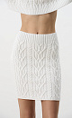 Трикотажная юбка длины мини из вискозы и хлопка. Модель с широким эластичным поясом. Изделие декорировано фактурной вязкой в виде кос разной толщины. Края выполнены в рубчик.
