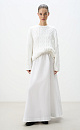 Трикотажный джемпер из вискозы и хлопка. Модель свободного силуэта со спущенной линией плеч, объемными рукавами и круглым вырезом горловины. Изделие декорировано фактурной вязкой в виде кос разной толщины. Края выполнены в рубчик.