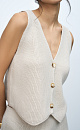 Трикотажный жилет из шерсти. Модель прямого кроя с глубоким V-образным вырезом и застежкой на пуговицы. Дополнить образ можно юбкой в таком же стиле.