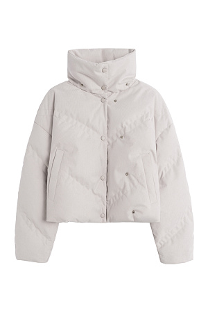 молочный Пуховик с воротником-стойкой, съемным капюшоном и графичной стежкой с двойной отстрочкой. Модель имеет два варианта застежки на металлические кнопки. Низ изделия выполнен на кулиске.