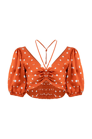 оранжевый Атласный топ из 100% вискозы в горошек, с рукавами-фонариками и кулиской. Дополнить образ можно брюками в таком же стиле.