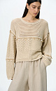 Трикотажный джемпер из хлопка, декорированный тесьмой с крупными бусинами. Модель свободного силуэта со спущенной линией плеча. Дополнить образ можно юбкой в таком же стиле.