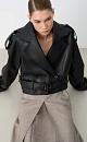 Двубортный жакет-косуха из двусторонней экокожи. Модель свободного силуэта со спущенным плечом и широкими лацканами. Изделие декорировано патами на плечах и ремнями с крупными пряжками на поясе и рукавах. 