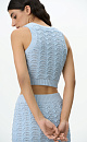 Трикотажный ажурный топ из хлопка с добавлением эластана. Модель приталенного силуэта, без рукавов, с неглубоким круглым вырезом горловины. Изделие выполнено объемным вязанием с волнистым узором и краями в рубчик. 