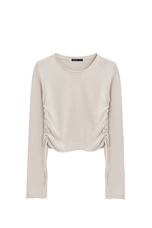 бежевый Трикотажный топ из вискозы. Модель прямого кроя, с длинным рукавом, небольшими разрезами на манжетах и круглым вырезом горловины. Кулиски по бокам изделия позволяют регулировать длину и создавать драпировку.