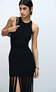Трикотажное платье длины мини из мягкой вискозы. Модель прителенного лисуэта, без рукавов и круглым вырезом горловины. Изделие декорировано бахромой из широких лент.