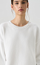 Трикотажный джемпер из хлопка с добавлением эластана. Модель свободного силуэта о спущенной линией плеч и круглым вырезом горловины. Изделие декорировано валиками по низу и на манжетах рукавов. 