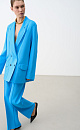 Трикотажный двубортный жакет из вискозы. Модель свободного кроя, с длинными лацканами, вывязанными карманами и застежкой на пуговицы. Дополнить образ можно брюками.