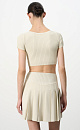 Короткий трикотажный топ из вискозы в рубчик. Модель приталенного силуэта с короткими рукавами и круглым вырезом горловины. Дополнить образ можно юбкой плиссе.