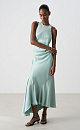 Атласное платье длины макси. Модель приталенного силуэта, с круглым вырезом горловины, без рукавов. Модель декорирована асимметричной юбкой и драпировкой на талии.