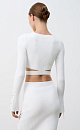 Укороченный трикотажный топ из вискозы. Модель приталенного силуэта, с декоративными горизонтальными разрезами на талии, длинными рукавами, декорированными люверсами и шнуровкой, и круглым вырезом горловины. Изделие выполнено в широкий рубчик. Дополнить образ можно юбкой в таком же стиле.