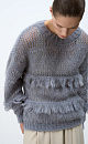 Ажурный джемпер с вывязанным узором и бахромой. Модель свободного силуэта со спущенной линией плеч и круглым вырезом горловины. Края изделия выполнены в рубчик. 