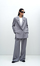 Классический костюм, состоящий из однобортного жакета и брюк палаццо. Жакет прямого кроя судлиненной спинкой, лацканами и двумя прорезными карманами с клапанами. Брюки прямого кроя с боковыми карманами и застежкой на молнию.