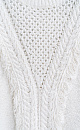 Трикотажный джемпер изо льна с добавлением хлопка. Модель свободного силуэта со спущенной линией плеча и круглым вырезом горловины. Изделие декорировано вывязанными крупными косами и длинной бахромой. Края изделия выполнены в рубчик.