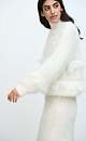 Ажурный джемпер с вывязанным узором и бахромой. Модель свободного силуэта со спущенной линией плеч и круглым вырезом горловины. Края изделия выполнены в рубчик. 