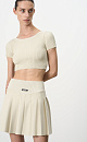 Короткий трикотажный топ из вискозы в рубчик. Модель приталенного силуэта с короткими рукавами и круглым вырезом горловины. Дополнить образ можно юбкой плиссе.