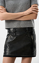 Юбка длины мини из экокожи. Модель по фигуре, со шлевками на поясе для ремня и карманами сзади. Изделие декорировано имитацией потертостей по швам и логотипом бренда. На подкладке. Застежка на молнию сбоку.