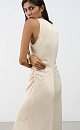 Атласное платье длины макси. Модель приталенного силуэта, с круглым вырезом горловины, без рукавов. Модель декорирована асимметричной юбкой и драпировкой на талии.