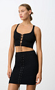 Короткий трикотажный топ из вискозы. Модель приталенного силуэта, без рукавов, на широких бретельках, с люверсами и шнуровкой на груди. Дополнить образ можно юбкой в таком же стиле.