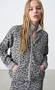 Трикотажный бомбер из вискозы с анималистичным принтом, имитирующим пятна леопарда. Модель свободного кроя, со спущенной линией плеч, воротником-стойкой и двумя боковыми карманами. Застежка на молнию. Края изделия выполнены в рубчик.