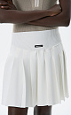 Трикотажная юбка длины мини в теннисном стиле. Модель с широким эластичным поясом в рубчик. Изделие декорировано брендированным ярлыком.