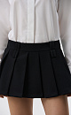 Юбка длины мини в складку из поливискозы. Модель с широким поясом и двойными шлевками для ремня. Застежка на потайную молнию. Изделие выполнено на подкладке из вискозы в виде шортиков.