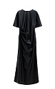 Длинное платье из экокожи. Модель свободного силуэта с коротким рукавом и круглым вырезом горловины. Изделие декорировано драпировкой и разрезом сбоку.