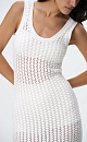 Трикотажное ажурное платье длины мини из хлопка. Модель приталенного силуэта без рукавов и U-вырезом горловины. Низ изделия декорирован бахромой. Без подкладки. 