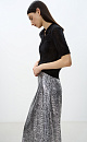 Юбка длины макси из текстурной ткани с анималистичным принтом, имитирующим чешую змеи. Изделие декорировано небольшими пайетками. Модель прямого силуэта. Застежка на молнию. На подкладке.