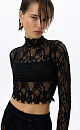 Укороченный топ с кружевом. Модель свободного силуэта с застежкой на молнию. Дополнить образ можно юбкой в таком же стиле.