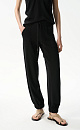 Трикотажные брюки-джоггеры из хлопка с добавлением вискозы. Модель выполнена в спортивном стиле, с широким эластичным поясом на кулиске, боковыми карманами и широкими манжетами на резинке.