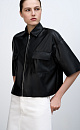Укороченная рубашка из экокожи. Модель свободного силуэта со спущенной линией плеча, накладными карманами на груди и застежкой на молнию.