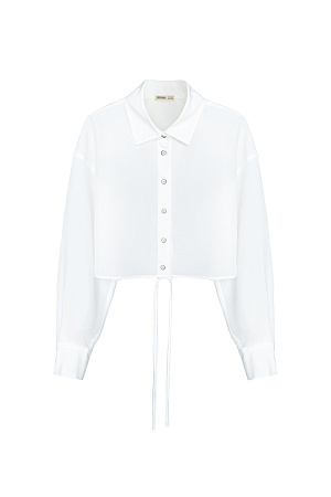 белый Укороченная рубашка с завязками. Модель свободного силуэта со спущенной линией плеча, манжеты на пуговицах. Дополнить образ можно юбкой в таком же стиле.
