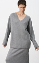 Удлиненный трикотажный джемпер из шерсти с добавлением кашемира. Модель свободного силуэта со спущенной линией плеча и глубоким V-образным вырезом. Дополнить образ можно комплектной юбкой.